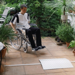 Rollstuhlfahrer vor eine Schwellenrampe